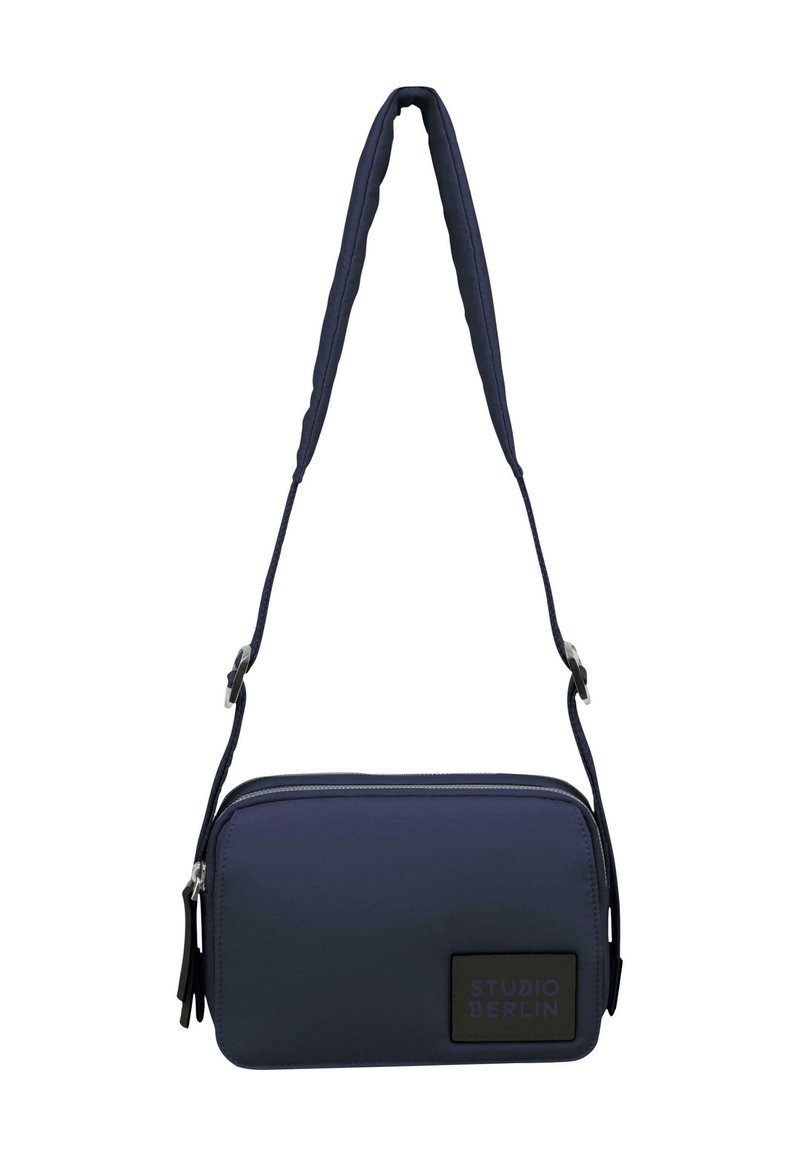 Borsa a tracolla blu navy realizzata in materiale resistente, con una forma rettangolare elegante, chiusura con zip e una patch del logo con una tracolla regolabile.