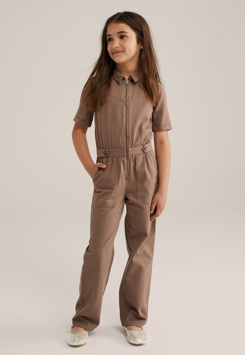 Jumpsuit de algodón marrón con mangas cortas, cierre de cremallera en el frente y detalles de botones en la cintura. Cuenta con dos bolsillos laterales y un diseño de pierna recta.