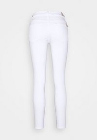 Jeans blancos ajustados con cintura alta, que cuentan con bolsillos traseros y una textura suave. El diseño es ceñido al cuerpo con un corte clásico.