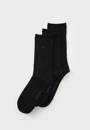 Three pairs of black socks made from a smooth fabric. Each has a cuffed top and a logo printed in gray on the exterior side.