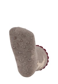 Braune Stricksocken mit einem gewellten, burgunderfarbenen Saum und rutschfesten, herzförmigen Gummipunkten an der Sohle. Weiche Textur, knielang.