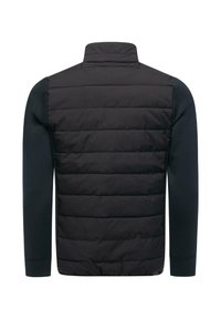 Topattu musta hihaton takki, jossa on korkea kaulus ja kontrastina tummansinisiä pitkiä hihoja. Takana on vaakasuuntainen tikattu ommel.