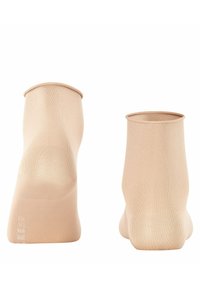 Beige kniehoge sokken van glad, rekbaar materiaal met een naadloos ontwerp. Bevat een geribde rand en subtiele branding aan de zijkant.