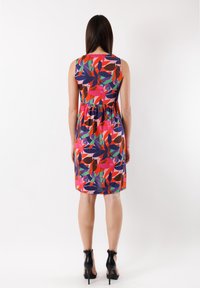 Une robe sans manches présentant un motif floral multicolore vibrant sur un fond sombre, avec un corsage ajusté et une jupe évasée.