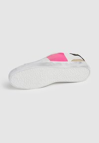 Suela de zapatilla blanca con goma texturizada. Presenta acentos en rosa y negro en la parte superior, hecha de materiales de cuero y ante.
