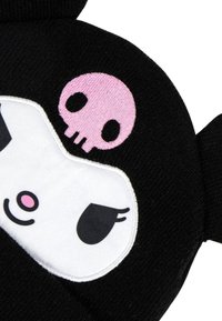 Guanto di stoffa nero con una faccia di personaggio bianca, occhi neri e un accento rosa, decorato con un piccolo teschio rosa sopra.