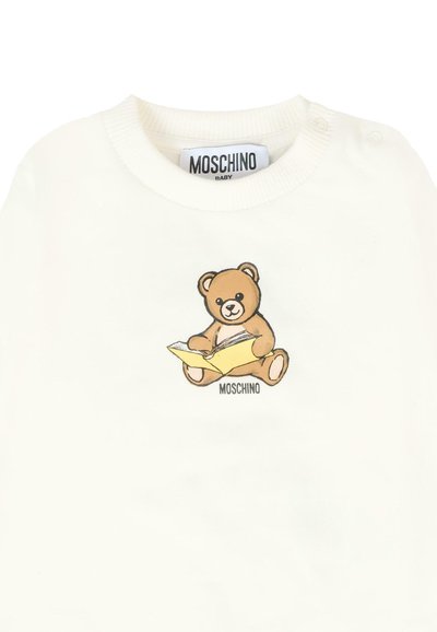 Felpa bianca con un orsetto dei cartoni animati che legge un libro, con il testo "Moschino" sotto l'illustrazione. Materiale in cotone con colletto a coste.