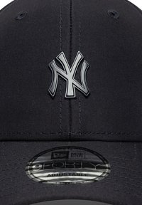 Fekete baseball sapka struktúrált dizájnnal, kiemelkedő ezüst New York Yankees logóval és állítható pánttal a hátsó részen.