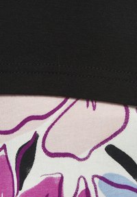 Schwarzes Oberteil über einem gemusterten Stoff mit rosa und weißen Blumen, die schwarze und lila Akzente aufweisen, und einer glatten Textur sowie einer figurbetonten Passform.