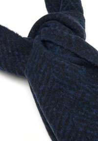 Sciarpa blu scuro realizzata in un morbido tessuto testurizzato, con un motivo sottile. La sciarpa è annodata e drappeggiata.