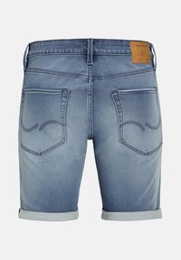Short en jean bleu avec revers remontés, deux poches arrière avec détails de couture, et un patch en cuir marron de la marque sur la taille.