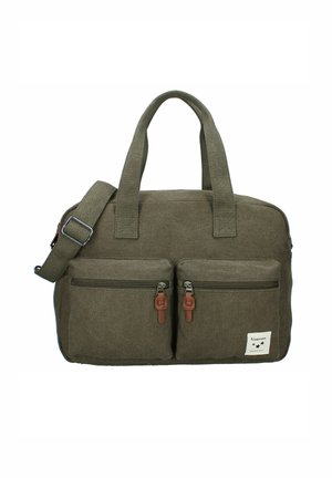 Sac en toile vert olive avec deux poches zippées à l'avant, deux poignées et une bandoulière ajustable. Étiquette blanche sur la poche inférieure droite.