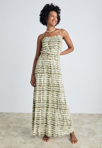 Maxi dress featuring a green and brown tie-dye pattern, adjustable spaghetti straps, gathered waist, and a flowy silhouette.