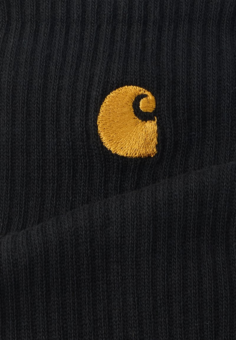 Black ribbed fabric with a smooth texture featuring a circular orange and black embroidered logo. Highlighted fold creates depth.