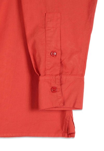 Poignet de chemise rouge à manches longues avec deux boutons rouges et coutures visibles, en tissu uni tissé.