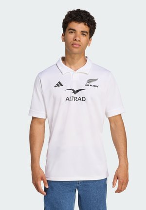 Bijela ragbi polo majica s teksturiranim završetkom, crnim logom (All Blacks, Adidas), s tri gumba i kratkim rukavima.