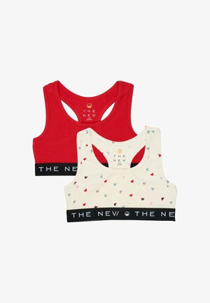 Deux brassières de sport pour filles, une rouge unie et une blanche avec des cœurs multicolores, toutes deux avec des bandes élastiques noires portant la mention "THE NEV."