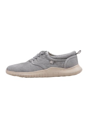 Zapatillas deportivas de color gris claro con una parte superior de suave gamuza, diseño de cordones y una suela de goma beige flexible con agarre texturizado.