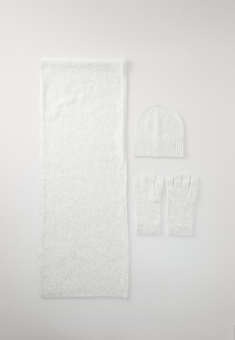 Bufanda blanca, gorro y guantes sin dedos hechos de una suave tela texturizada con un sutil brillo, que presentan detalles acanalados en el gorro y los guantes.