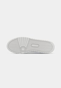 Shoe sole in white rubber with textured herringbone pattern and circular accent. Rounded edges with small grip nubs along the perimeter.