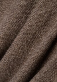 Brauner Wollstoff mit einer weichen Textur und einem subtilen Melange-Muster, das diagonale Drapierungen aufweist, die seine Wärme und Dicke zur Schau stellen.