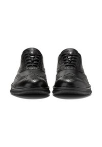 Černé kožené společenské boty s hladkým povrchem, ozdobené perforovanými detaily, s kulatou špičkou, šněrováním a texturovanou gumovou podrážkou.