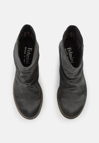 Botas de tobillo de ante negras con un diseño arrugado, punta redondeada y superficie texturizada. El forro interior presenta un patrón de rayas coloridas.