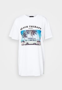 Bílá bavlněná tričko s grafickým potiskem dodávky a palem se textem "BEACH THERAPY 1975" v tučném černém písmu.