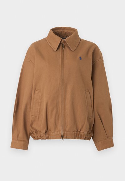 Καφέ μπουφάν με φερμουάρ, γιακά, ελαστική μέση, πλαϊνές τσέπες και μικρό ναυτικό λογότυπο στο αριστερό στήθος.