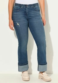 Vaaleansiniset farkut, suorat lahkeet, käännettävä helma, hieman kuluneet ja repaleiset kohdat sekä joustava vyötärö mukavuutta varten.