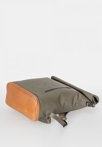 Zaino a roll-top realizzato in tessuto verde oliva con dettagli in pelle marrone. Presenta una tasca frontale con zip e spallacci regolabili.
