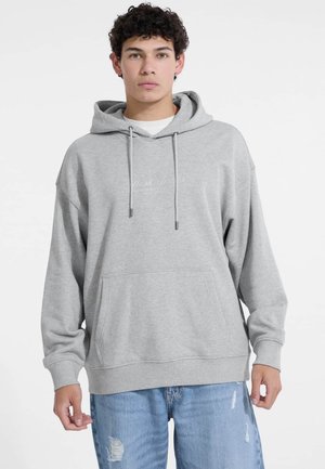 Grijze hoodie met een voorzak, trekkoorden en een subtiele geborduurde logo. Katoenmix stof, relaxed fit en ribgebreide manchetten.