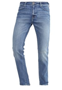 Vaqueros de denim azul con corte recto, desvanecimiento sutil, diseño de cinco bolsillos y cierre con botón de metal en la cintura.