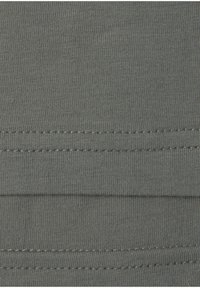 Gray cotton fabric with a ribbed texture, featuring parallel stitching along the edges, showcasing a smooth surface and consistent color.