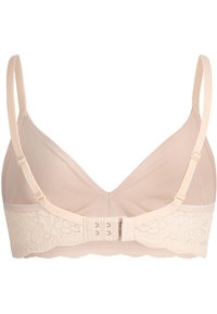 Soutien-gorge beige clair en tissu doux, avec des bretelles ajustables, une bordure en dentelle festonnée et une fermeture croisée à l'arrière.