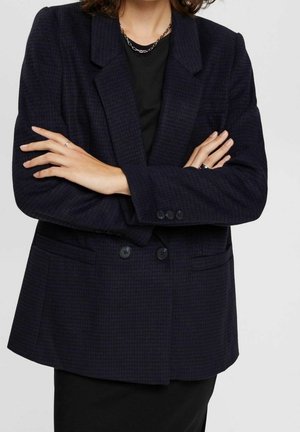 Blazer a scacchi navy con frontale doppiopetto, rever a punta e tessuto testurizzato. Presenta due tasche frontali e decorazioni con bottoni.