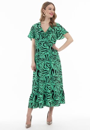 Zöld ruha fekete zebra mintával, rövid, fodros ujjakkal, V-kivágással és fodros szegéllyel. Sima anyag, laza fazonban.