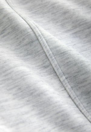 Světlé šedé plátno s měkkým, texturovaným povrchem. Má jemný melírovaný vzor a viditelné stehy podél okrajů.