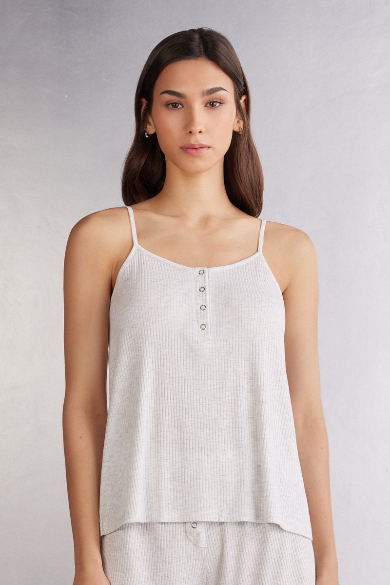 Světlé šedé žebrované tílko s tenkými ramínky, s knoflíkovou légou na výstřihu a volným střihem. Hladký materiál.