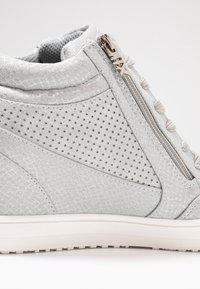 Graue High-Top-Sneaker aus perforiertem Material, mit strukturierten Einsätzen, seitlichem Reißverschluss und hellgrauen Schnürsenkeln. Verfügt über einen gepolsterten Kragen und eine Gummisohle.