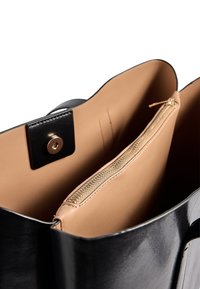 Juodas odinis krepšys su šviesiai rudos spalvos vidumi. Yra užtrauktuko skyrius ir spaudžiamas uždarymas, pabrėžiantis glotnias tekstūras ir švarias linijas.