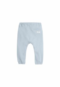Lichtblauwe katoenen joggingsbroek met een elastische tailleband, gebrogde enkels en een enkel zakje aan de achterkant. Minimalistisch ontwerp met een label.
