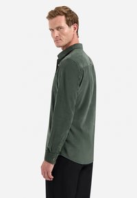 Groene corduroy shirt met een knoopsluiting, zijzak en knoopmanchetten, met een zachte textuur en een relaxte pasvorm.