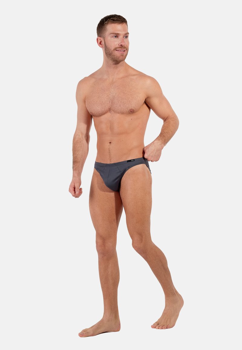 Grijze zwembroek met een lage taille. Gemaakt van rekbaar materiaal, met minimale stiknaden en een klein logo-label op de tailleband.