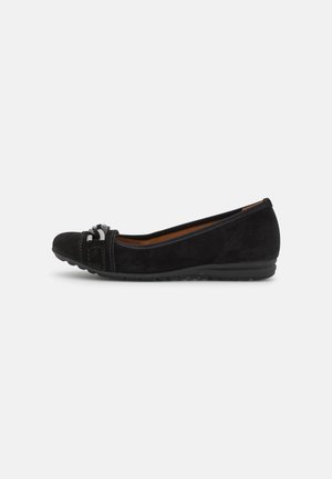 Black suede ballet flats with a rounded toe, decorative accent at the front, and a flexible black outsole. Smooth texture, simple design.