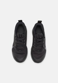 Pair of black Nike athletic shoes with mesh uppers, laces tied, and pull tabs, viewed from above on a white background.