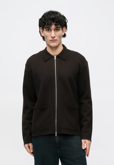 Ciemnobrązowa kurtka zapinana na zamek z kołnierzem, teksturowanym materiałem, dwoma przednimi kieszeniami i luźnym krojem. Odpowiednia do codziennego noszenia.