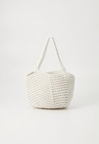 Woven white tote bag with a rounded shape, two handles, and a textured surface. Minimalist design with no visible hardware or patterns.