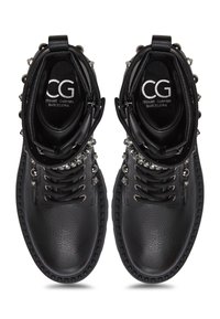 Botas de cuero negras hasta el tobillo con acentos de tachuelas, punta redonda, diseño de cordones y un acabado texturizado. Interior marcado con "CG Barcelona."