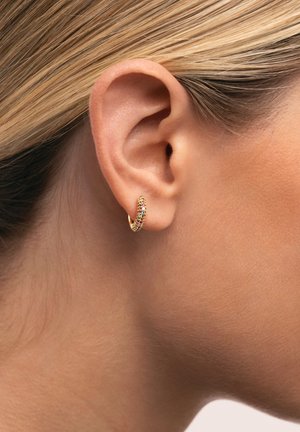 Pendiente de aro de oro con piedras preciosas multicolores incrustadas a lo largo del borde frontal, con un acabado liso y pulido.